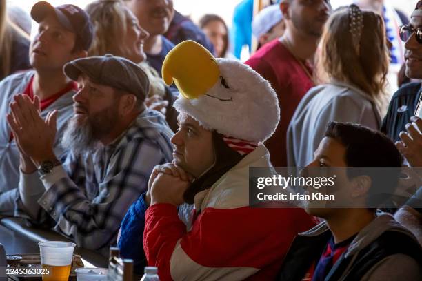 Hermosa Beach, CA Eyes of Robbie Crauder, center, in bald eagle head gear and others are glued on TV screens watching U.S. Men's national team...