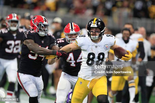 Pittsburgh Steelers tight end Pat Freiermuth breaks free from the grip of Atlanta Falcons linebacker Rashaan Evans during the Sunday afternoon NFL...