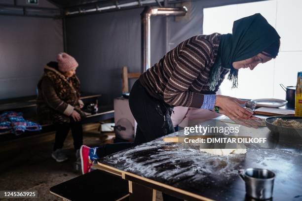 Local resident, living in a modular town after her house has been destroyed, cooks in a tent where she can keep warm in Borodyanka, near Kyiv on...