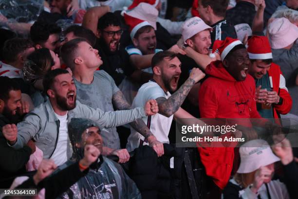 England fans cheer as England score their second goal in their Round of 16 FIFA World Cup match against Senegal at BOXPARK Croydon on December 4,...