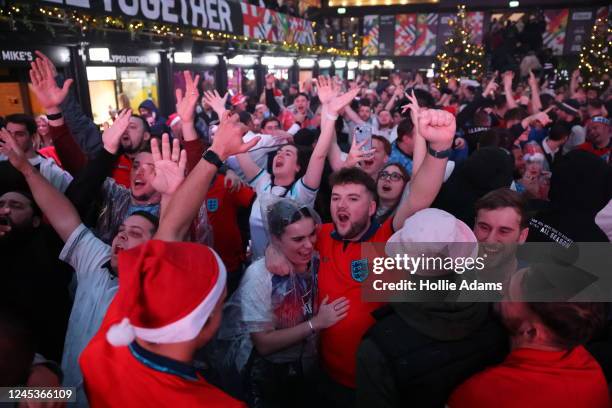 England fans cheer as they celebrate England's victory in their Round of 16 FIFA World Cup match against Senegal at BOXPARK Croydon on December 4,...