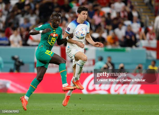 Famara Diedhiou of Senegal and Harry Maguire of England challenge during the FIFA World Cup Qatar 2022 Round of 16 match between England and Senegal...