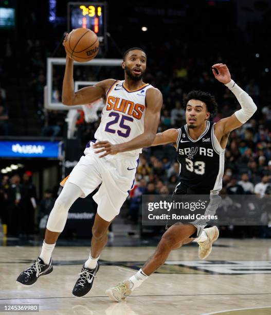 Mikal Bridges of the Phoenix Suns drives around Tre Jones of the San Antonio Spurs in the second half of the game at AT&T Center on December 4, 2022...