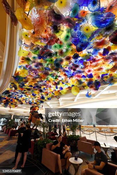 Guests gather under the "Fiori di Como" glass sculpture by artist Chihuly in the lobby of Bellagio Resort & Casino on the Las Vegas Strip after the...