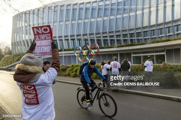 Woman holds a poster in support of boxing at the Olympics Games on the sidelines of the Executive Board meeting, in front of the Olympic House, in...