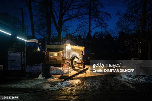 Residents prepare food on a street in the town of Irpin, northwest of Kyiv, amid the Russian invasion of Ukraine on December 4, 2022.