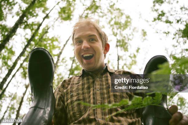 happy quaint man in green foliage - homme en contre plongée fait le pitre photos et images de collection