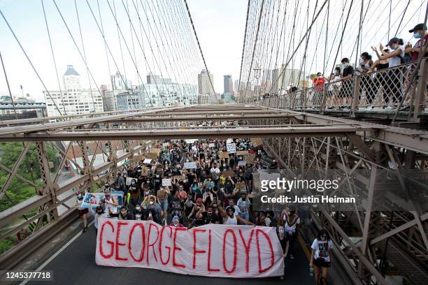 People walk over the Brooklyn Bridge following a memorial service for George Floyd, the man killed by a Minneapolis police officer in Brooklyn’s...