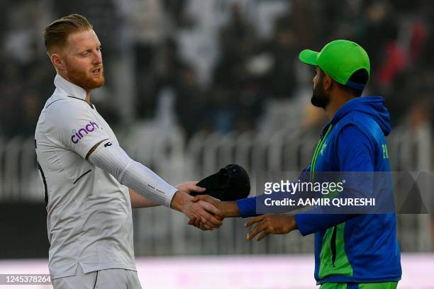 England's Ben Stokes shakes hands with Pakistan's captain Babar Azam after their victory at the end of the fifth and final day of the first cricket...