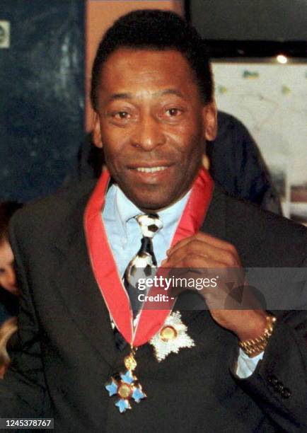 Former Brazilian soccer legend and now his country's Minister for Sport, Pele, shows off his KBE awarded to him by the Queen at an InvestIture at...