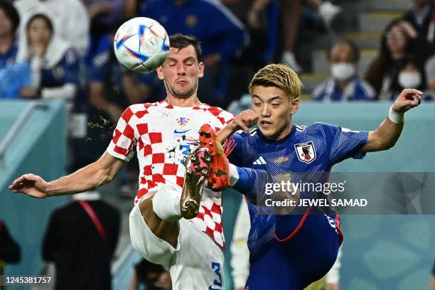 Croatia's defender Borna Barisic fights for the ball with Japan's midfielder Ritsu Doan during the Qatar 2022 World Cup round of 16 football match...