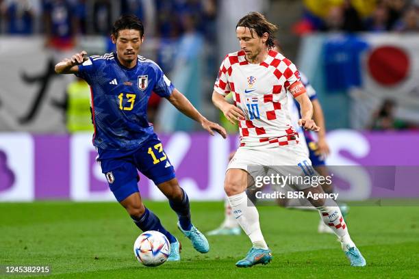 Hidemasa Morita of Japan battles for the ball with Luka Modric of Croatia during the Round of 16 - FIFA World Cup Qatar 2022 match between Japan and...