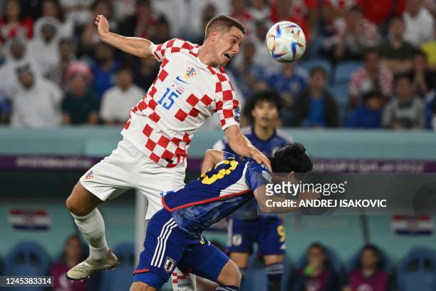 Croatia's midfielder Mario Pasalic heads the ball past Japan's midfielder Takumi Minamino during the Qatar 2022 World Cup round of 16 football match...