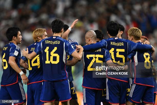 Japan's players celebrate their first goal during the Qatar 2022 World Cup round of 16 football match between Japan and Croatia at the Al-Janoub...