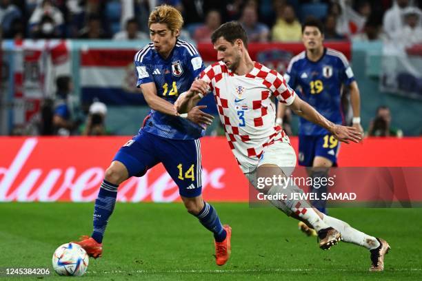 Japan's midfielder Junya Ito fights for the ball with Croatia's defender Borna Barisic during the Qatar 2022 World Cup round of 16 football match...