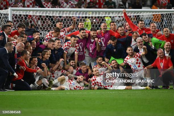 Croatia players and staff members celebrate winning after penalty shoot-out the Qatar 2022 World Cup round of 16 football match between Japan and...