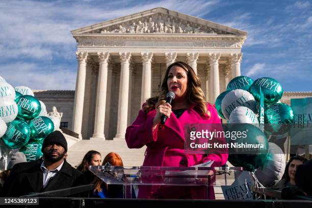 Lorie Smith, a Christian graphic artist and website designer in Colorado, center in pink, speaks to supporters outside the Supreme Court on Monday,...