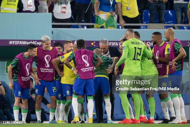 Richarlison of Brazil celebrates scoring his sides third goal with the Manager Tite and the substitutes bench during the FIFA World Cup Qatar 2022...