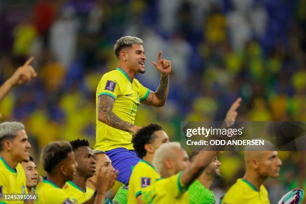 Brazil's midfielder Bruno Guimaraes celebrates with his teammates after they won the Qatar 2022 World Cup round of 16 football match between Brazil...