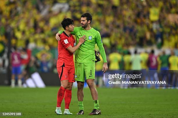 South Korea's midfielder Son Heung-min is consoled by Brazil's goalkeeper Alisson after his team lost the Qatar 2022 World Cup round of 16 football...
