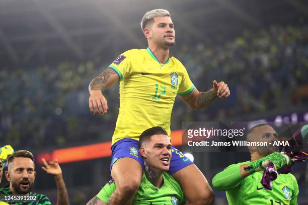 Bruno Guimaraes of Brazil celebrates victory at full time on the shoulders of Ederson of Brazil during the FIFA World Cup Qatar 2022 Round of 16...