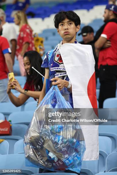 Japanese fan tidies up rubbish from the stadium despite their defeat during the FIFA World Cup Qatar 2022 Round of 16 match between Japan and Croatia...
