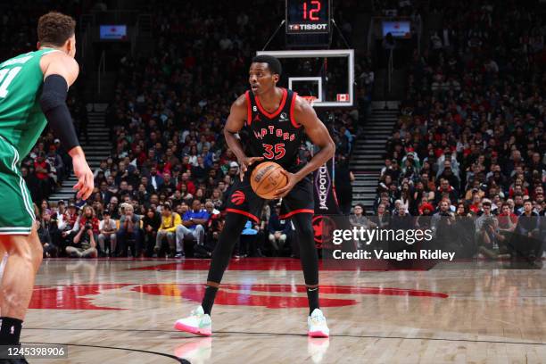 Christian Koloko of the Toronto Raptors looks to pass the ball during the game against the Boston Celtics on December 5, 2022 at the Scotiabank Arena...