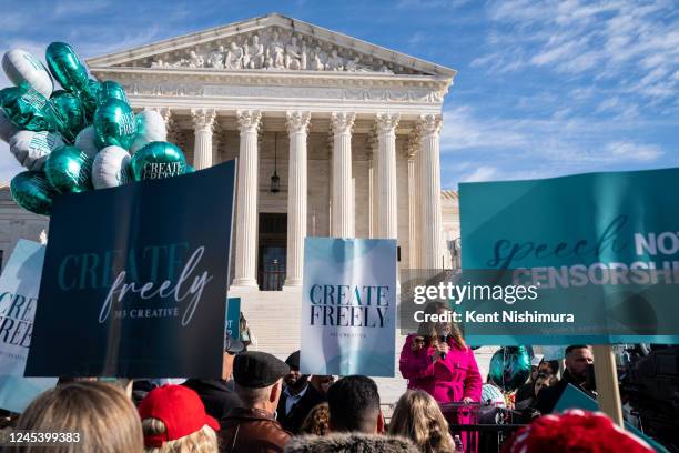 Lorie Smith, a Christian graphic artist and website designer in Colorado, center in pink, speaks to supporters outside the Supreme Court on Monday,...