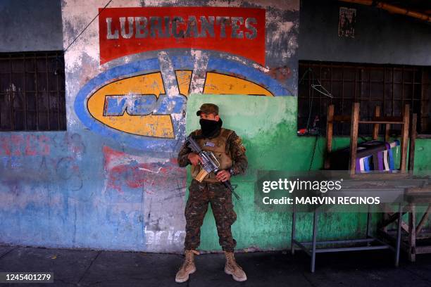 Soldier stands guard in front of a closed business during an operation against criminal gangs, in Soyapango, El Salvador, on December 5, 2022. - The...