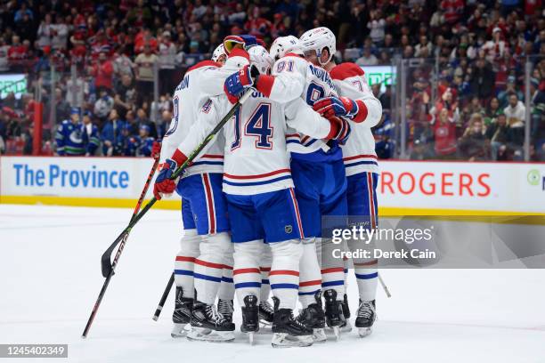 Sean Monahan is congratulated by Mike Matheson Nick Suzuki and Kirby Dach of the Montréal Canadiens after scoring a goal against the Vancouver...