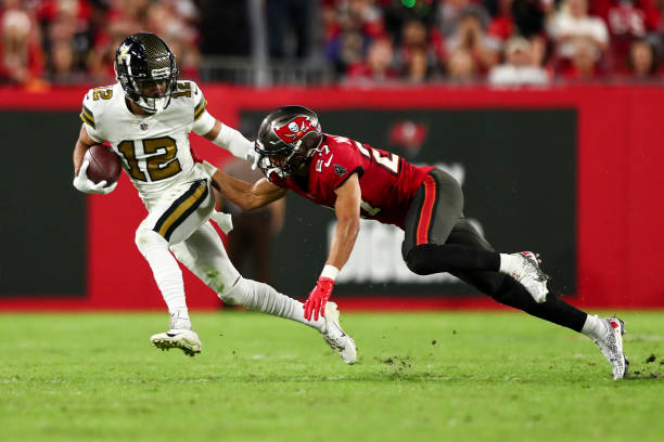 Chris Olave of the New Orleans Saints stiff arms Zyon McCollum of the Tampa Bay Buccaneers during the fourth quarter of an NFL football game at...