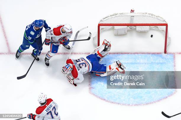 Curtis Lazar watches a goal by Jack Studnicka of the Vancouver Canucks on Sam Montembeault of the Montréal Canadiens during the third period of their...