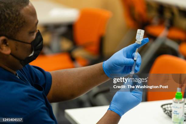 Healthcare employee prepares a syringe with the Moderna COVID-19 vaccine at the Dennis Avenue Health Center in Silver Spring, Maryland on November...