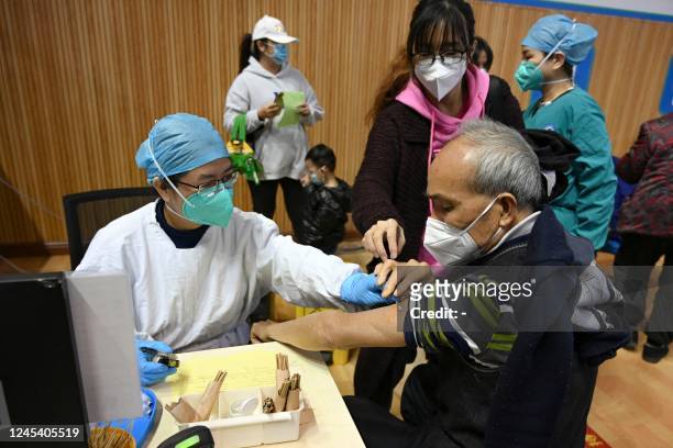 Resident receives a Covid-19 vaccine in Guangzhou, in China's southern Guangdong province on December 6, 2022. - China OUT / China OUT