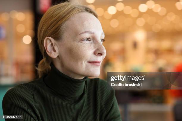 indoors portrait of a 45 year old red-haired woman with freckles - redhead stock pictures, royalty-free photos & images