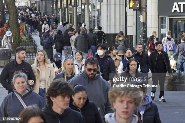 People walk past stores in the 500 block of North Michigan Avenue in Chicago on Nov. 25, 2022.