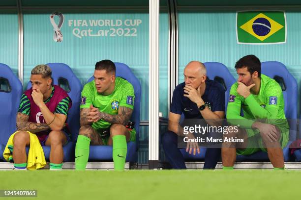 Antony, Ederson and Allison sit with goalkeeping coach Claudio Taffarel during the FIFA World Cup Qatar 2022 Round of 16 match between Brazil and...