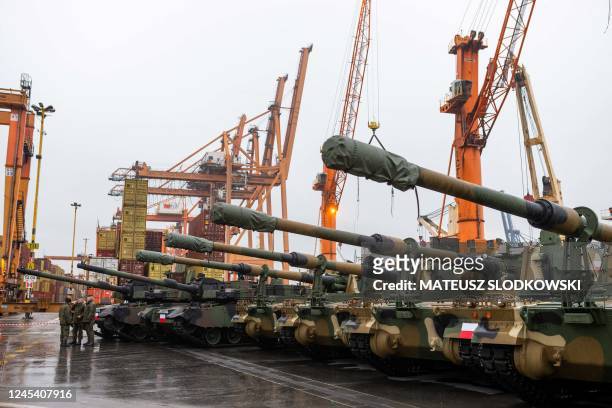 Polish Army soldiers stand in front of army equipment in the port after the arrival of the first K2 tanks and K9 howitzers for Poland on December 6,...