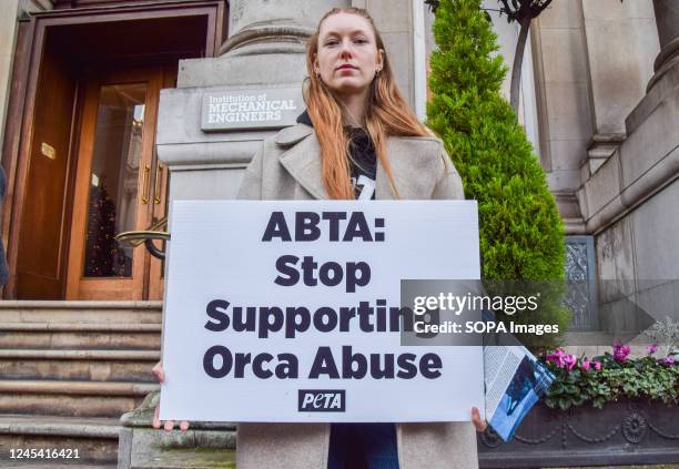 Protester holds a placard demanding that 'ABTA stop supporting orca abuse' during the demonstration. PETA activists staged a protest outside the...