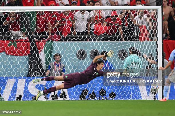 Morocco's goalkeeper Yassine Bounou dives to save a shot by Spain's forward Pablo Sarabia during penalty shoot-out in the Qatar 2022 World Cup round...