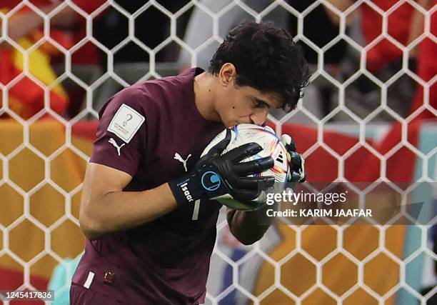 Morocco's goalkeeper Yassine Bounou kisses the ball during the penalty shoot-out during the Qatar 2022 World Cup round of 16 football match between...