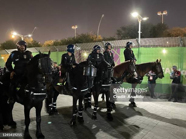 Qatari and Turkish police officers take security measures after Moroccan ticketless fans try to enter the Education City Stadium by knocking over...