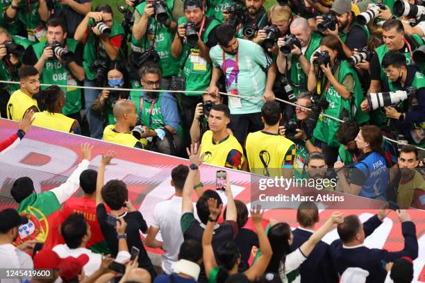 Cristiano Ronaldo of Portugal urrounded by photographers looks on from the substitutes bench during the FIFA World Cup Qatar 2022 Round of 16 match...