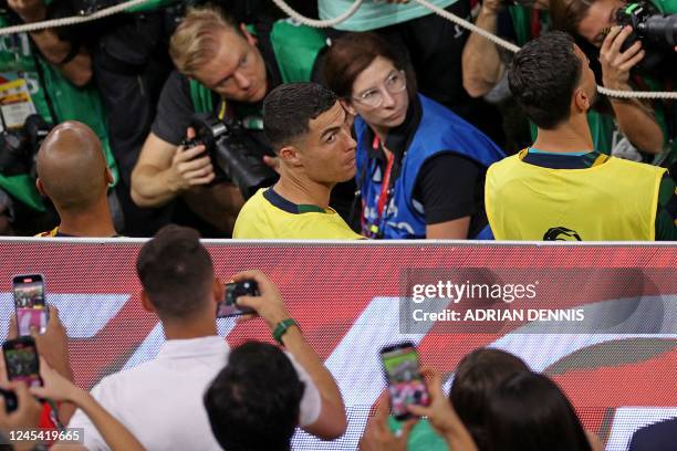 Portugal's forward Cristiano Ronaldo looks on as he is surrounded by photographers ahead of the Qatar 2022 World Cup round of 16 football match...