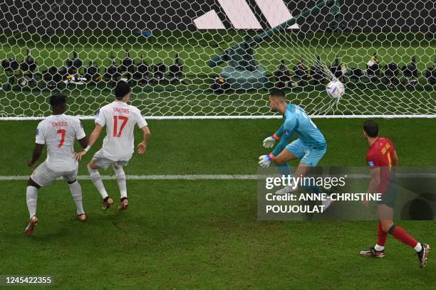 Switzerland's defender Manuel Akanji scores his team first goal past Portugal's goalkeeper Diogo Costa during the Qatar 2022 World Cup round of 16...