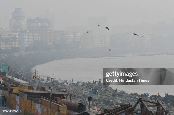 Citizens enjoy an evening with the city engulfed in smog amid hazy weather, at Marine Drive, on December 6, 2022 in Mumbai, India.