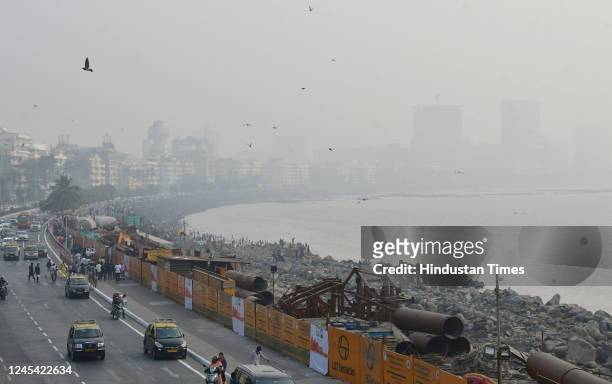 Citizens enjoy an evening with the city engulfed in smog amid hazy weather, at Marine Drive, on December 6, 2022 in Mumbai, India.