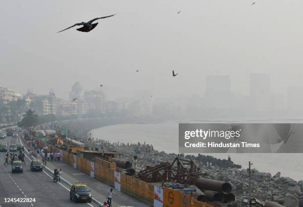 Citizens enjoy an evening with the city engulfed in smog amid hazy weather, at Marine Drive, on December 6, 2022 in Mumbai, India.