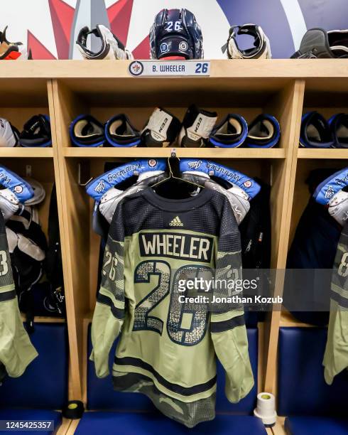 Canadian Armed Forces themed jersey hangs in the stall of Blake Wheeler of the Winnipeg Jets prior to NHL action against the Florida Panthers on...