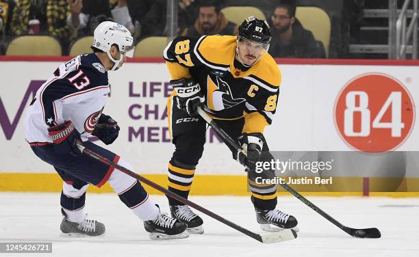 Sidney Crosby of the Pittsburgh Penguins controls the puck against Johnny Gaudreau of the Columbus Blue Jackets in the first period during the game...